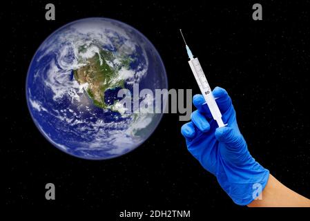 Début de la vaccination de masse mondiale contre le covid-19. Main femelle dans un gant médical bleu avec seringue donnant l'injection du vaccin à la planète Terre Banque D'Images