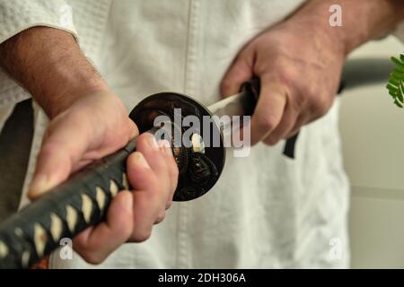 Les mains des hommes prennent une épée katana japonaise Banque D'Images