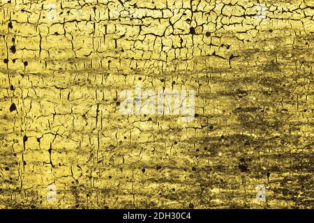 Vieux craquelé éclairant la texture de la peinture jaune. Grunge arrière-plan abstrait. Surface dorée. Couleur de l'année 2021. Banque D'Images