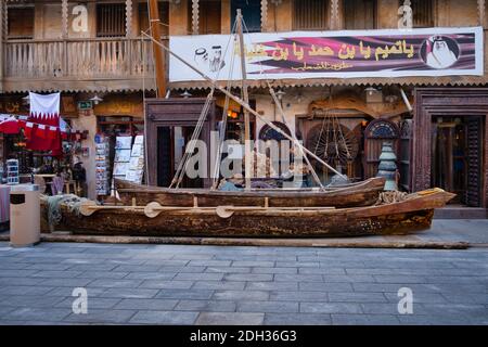 Souq Waqif Doha Qatar rue principale au coucher du soleil montrant traditionnel Bateau en bois arabe (Dhow) exposé devant la boutique d'antiquités Banque D'Images