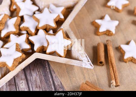 Biscuits à la cannelle de Noël émaillés en forme d'étoile allemande, appelés « Zimtsterne », fabriqués avec des amonds, du blanc d'œuf, du sucre, de la cannelle et de la farine en bois en forme d'étoile Banque D'Images