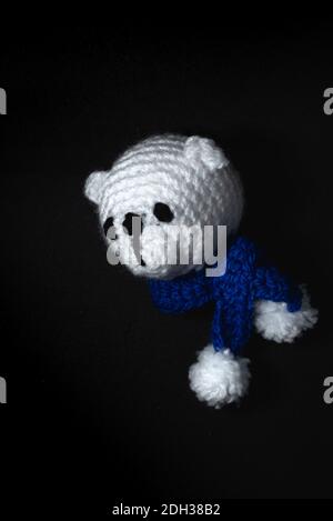 Portrait de l'ours de Noël Amigurumi en peluche crochetée ou tricotée sur fond noir Banque D'Images