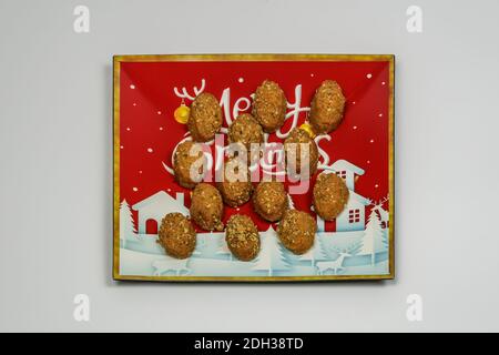 Bonbons traditionnels de Noël appelés melomakarona vue du dessus. Desserts festifs de saison à base de quatre, huile d'olive et miel décorés sur un plat. Banque D'Images