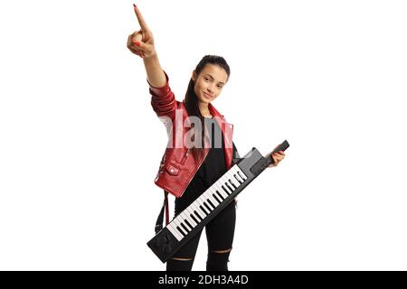 Jeune femme dans une veste en cuir avec un synthétiseur keytar pointant vers le haut isolé sur fond blanc Banque D'Images