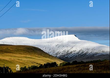 Vue sur le pic du ventilateur de PEN y à distance avec de la neige sur le dessus pendant les mois d'hiver dans le sud du pays de galles au royaume-uni. Beaucoup de marcheurs au sommet de la vue. Banque D'Images