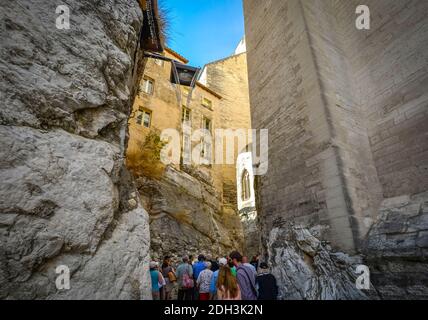 Un groupe suit son guide dans une ancienne section d'Avignon France, juste à l'extérieur du Palais des Papes. Banque D'Images