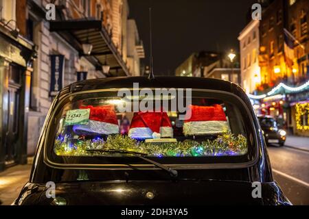 Une cabine à l'arrière avec des chapeaux de Noël festifs décorant sa fenêtre à l'arrière se trouve à Covent Garden, Londres, Angleterre, Royaume-Uni Banque D'Images