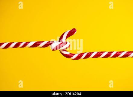 Sucettes de canne à sucre sur fond jaune, bonbons de Noël. Banque D'Images