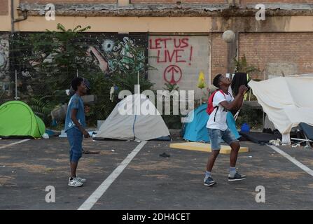 PAS DE WEB/PAS D'APPS - migrants bloqués dans un camp de fortune près de la gare de Tiburtina à Rome, Italie, le 24 juillet 2017. Mahmoud (R) et Mamadou, tous deux 16 et de Guinée, veulent aller en France. Il y a maintenant 100 migrants qui restent ici, principalement d'Afrique, alors qu'ils tentent de rejoindre d'autres pays européens. En fait vivre sans toilettes, électricité et eau courante. La plupart ont quitté les centres d'accueil pour y rester quelques jours avant de poursuivre leur voyage vers le nord, certains ignorant les frontières sont fermées à eux, d'autres ont décidé de réessayer après des tentatives infructueuses de traverser. Tout le monde ici a passé des semaines, m Banque D'Images