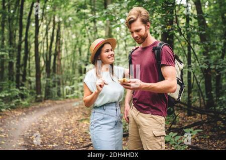 Couple utilisant un smartphone pour naviguer dans les bois. Thème tourisme et navigation, rechercher, créer un itinéraire, application de téléphone gps. Deux personnes Banque D'Images
