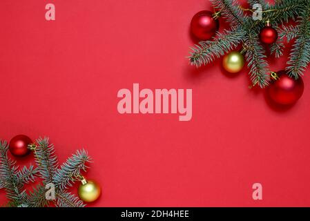 Cadre de Noël en branches de sapin, boules de Noël sur fond rouge avec espace pour le texte. Concept Noël et nouvel an. Banque D'Images