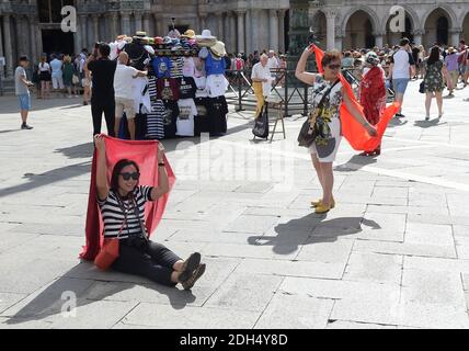 PAS DE WEB/PAS D'APPS - touristes asiatiques sur la Piazza San Marco, le centre de gravité touristique à Venise, Italie le 12 août 2017. La ville de Venise, envahie par les touristes, risque de devenir ‘la terre aride par la mer’. La plupart des Vénitiens méprisent les navires de croisière qui traversent le canal de Giudecca chaque jour, émettant des fumées, provoquant l'érosion des vasières et la perte de sédiments, avant de dégorger des milliers de personnes dans le centre historique. Qu'il soit irrité par des bâtons de selfie, des valises bruyantes à roulettes ou des gens qui s'accroché sur l'un des 391 ponts, le mépris des Vénitiens envers les 30 millions de visiteurs qui flo Banque D'Images