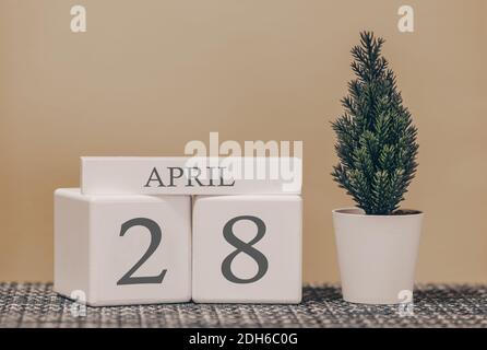 Calendrier de bureau pour une utilisation dans différentes idées. Mois de printemps - avril et le nombre sur les cubes 28. Calendrier des vacances sur fond beige. Banque D'Images