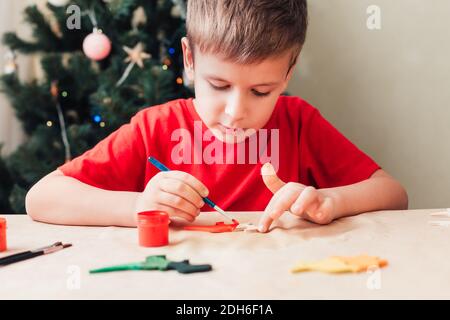 Mignon 7 ans enfant garçon peint en bois dinosaure jouet Pour arbre de Noël Banque D'Images