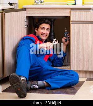 Plombier réparant le lavabo de la cuisine Banque D'Images