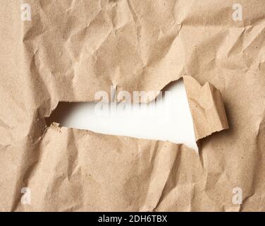 Papier kraft brun avec trou, bord recourbé, plein cadre Banque D'Images