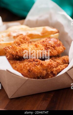 les doigts de poulet panés et les frites dans un récipient à emporter Banque D'Images