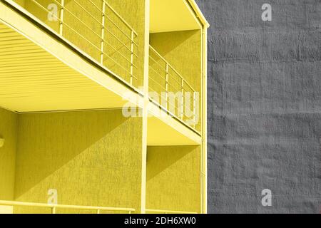 Vue sur les bâtiments en béton à texture murale jaune et grise avec balcon. Concept de couleur de 2021 ans. Banque D'Images