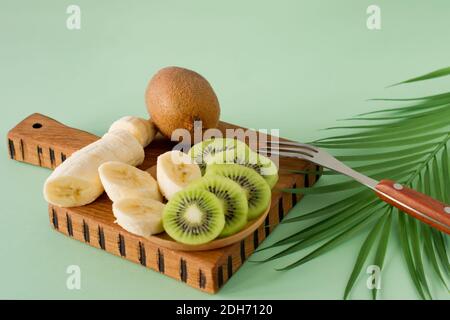 Fruits exotiques tranchés sur une planche à découper en bois, gros plan. Kiwi et banane en lamelles pour la cuisson de smoothie. Riche en vitamines et fruits frais, sain bio Banque D'Images