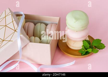 Boîte cadeau avec guimauves multicolores pastel maison. zephyr aux pommes de forme ronde. Délicieux dessert aux fruits sur fond rose. Banque D'Images