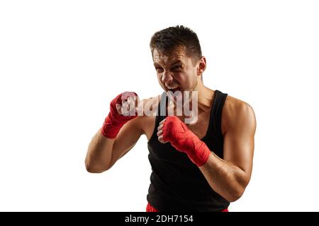 Homme sportif agressif dans les bandages de sport rouges sur ses mains combat isolé sur fond blanc Banque D'Images
