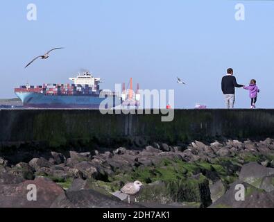 Plate-forme pétrolière en mer du Nord.conteneur de la mer du Nord entrant dans le port de Rotterdam à Hoek van Holland.Segulls volant et se reposant sur la jetée près de Hoek van Holland.Père et fille marchant sur la jetée à Hoek van Holland. Navire-conteneur de fret naviguant au-delà de Hoek van Holland.les pays-Bas. Banque D'Images