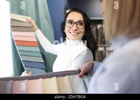 Le vendeur présente des échantillons de tissu pour rideaux Banque D'Images