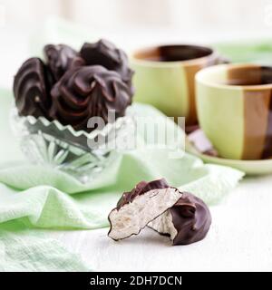 Guimauve blanche en chocolat et une feuille de menthe sur une table en bois. La vie plate, foyer sélectif. 1:1 Banque D'Images