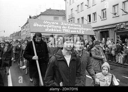 01 mai 1982, Saxe, Eilenburg: «notre objectif: Dépasser la production de biens de consommation de 4 pour cent en 1982». Lors de la manifestation à Eilenburg, le 1er mai 1982, des travailleurs, des écoliers, des sportifs, des femmes et des enfants défilent devant l'hôtel de ville et une tribune avec des invités d'honneur s'y trouve. Sur la droite se trouve un magasin HO. Photo: Volkmar Heinz/dpa-Zentralbild/ZB Banque D'Images