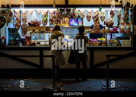 Berlin, Allemagne. 09e décembre 2020. Allemagne, Berlin, 09 décembre 2020: Deux femmes se tiennent sur un stand de bonbons avec des barrières pour maintenir les règles de distance sur le Kurfürstendamm illuminé de Noël. Pour contenir la pandémie de corona, de nombreuses restrictions s'appliquent à Berlin du 2 novembre à la fin de décembre 22 : les musées et les institutions culturelles doivent fermer, les événements et les marchés de Noël ne sont pas autorisés. (Photo de Jan Scheunert/Sipa USA) crédit: SIPA USA/Alay Live News Banque D'Images