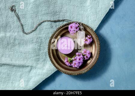 Concept d'aromathérapie. Bougie de thé parfumée, flacon en cristal et fleurs en vain, tiré du haut Banque D'Images