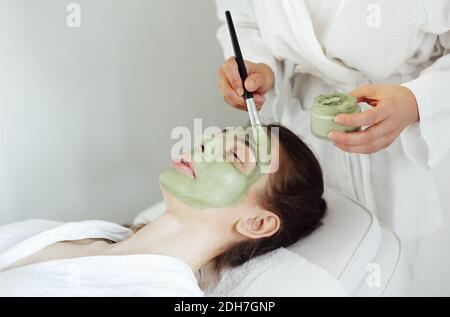 Belle femme détendue ayant un masque en argile dans le spa salon Banque D'Images