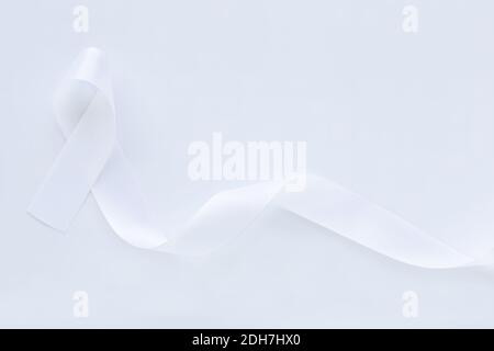 Boucle de ruban blanc perle sur fond blanc avec espace de copie. Sensibilisation au cancer du poumon, symbole du cancer du Mésothéliome et du rétinoblastome. Signe de pureté pour Banque D'Images
