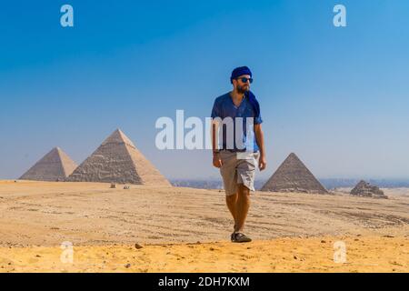 Un portrait d'un jeune homme dans un turban bleu marchant à côté des pyramides de Gizeh, le Caire, l'Égypte Banque D'Images