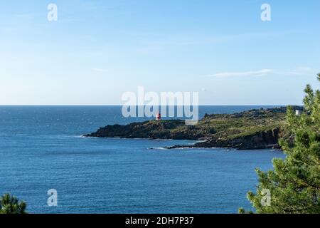 Vue sur le phare rouge lumineux de Punta Robaleira en Galice Banque D'Images