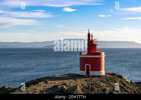 Vue sur le phare rouge lumineux de Punta Robaleira en Galice Banque D'Images