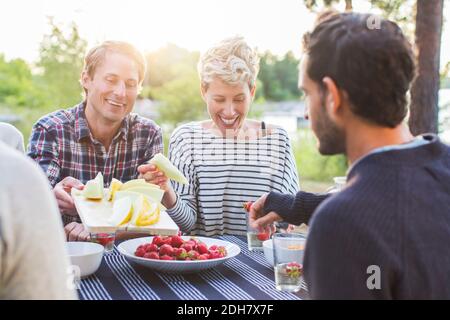 Des amis heureux prenant le déjeuner à la table de pique-nique Banque D'Images