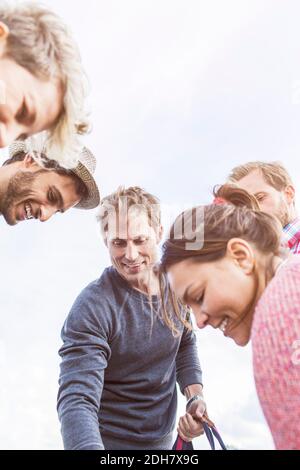 Vue en contre-angle des amis heureux contre le ciel Banque D'Images