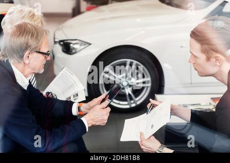 Le vendeur s'est montré d'accord avec le couple senior de la concession automobile Banque D'Images