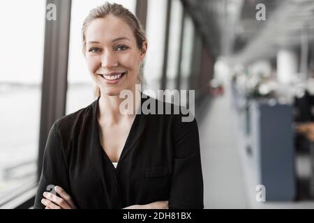 Portrait of happy businesswoman standing in office Banque D'Images