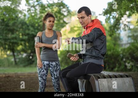 Homme regardant la montre-bracelet pendant que la femme touche le bracelet Banque D'Images