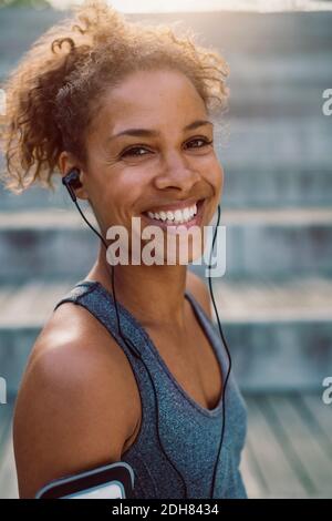 Portrait d'une femme souriante portant un casque et se tenant au parc Banque D'Images