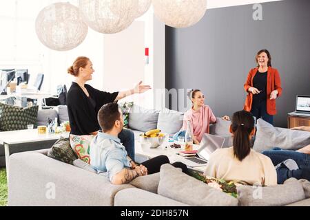 Des gens d'affaires multiethniques heureux en discussion dans le hall du bureau Banque D'Images