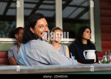 Portrait de l'homme heureux assis avec des amis à chalet en rondins Banque D'Images
