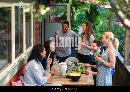 Vue en grand angle de vos amis multiethniques qui se réjouaperçoivent de la fête chez chalet en rondins Banque D'Images