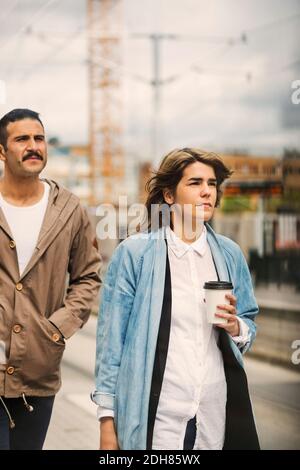 Passagers hommes et femmes marchant à la station de tramway Banque D'Images