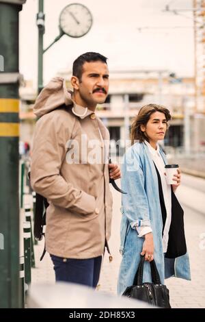 Homme et femme attendant à la station de tramway Banque D'Images