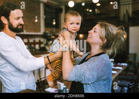 Parents heureux de mi-âge adulte avec bébé garçon dans le restaurant