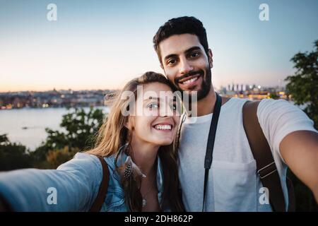 Portrait d'un couple touristique heureux contre ciel dégagé Banque D'Images