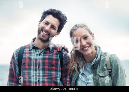 Portrait d'un couple heureux de merveilleux debout contre le ciel Banque D'Images